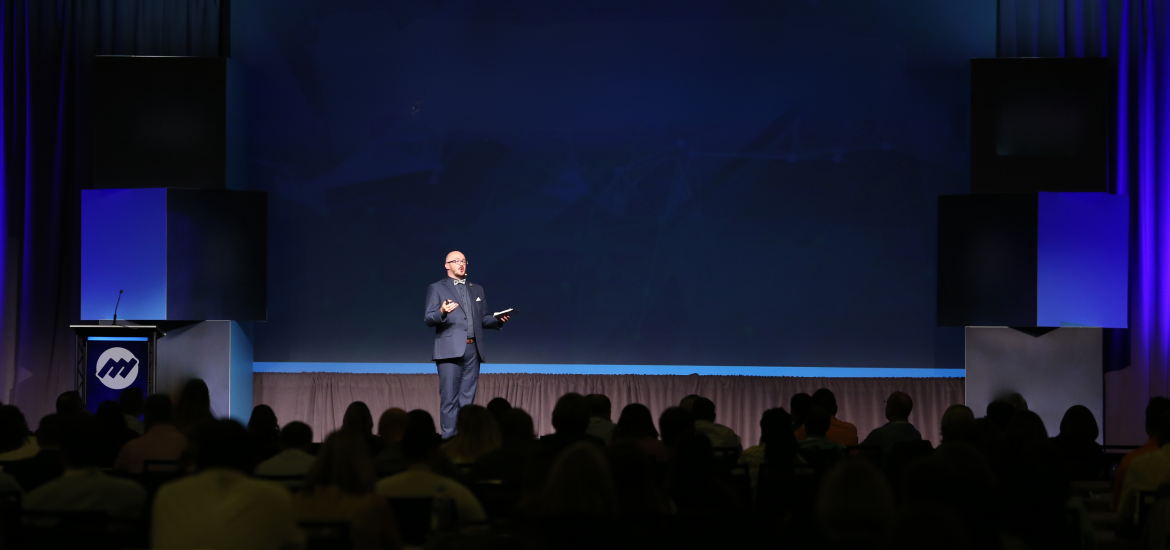 Justin Robbins delivers a keynote presentation in front of a crowd of customer experience professionals.